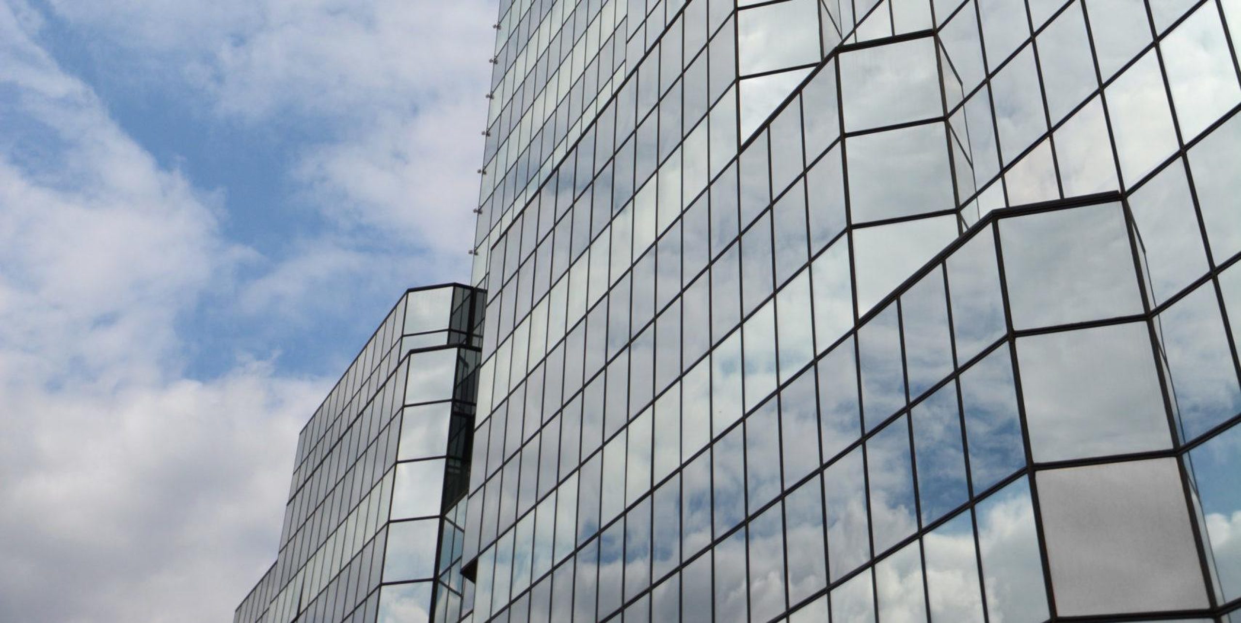 View looking up at skyscraper completely covered in mirrored windows