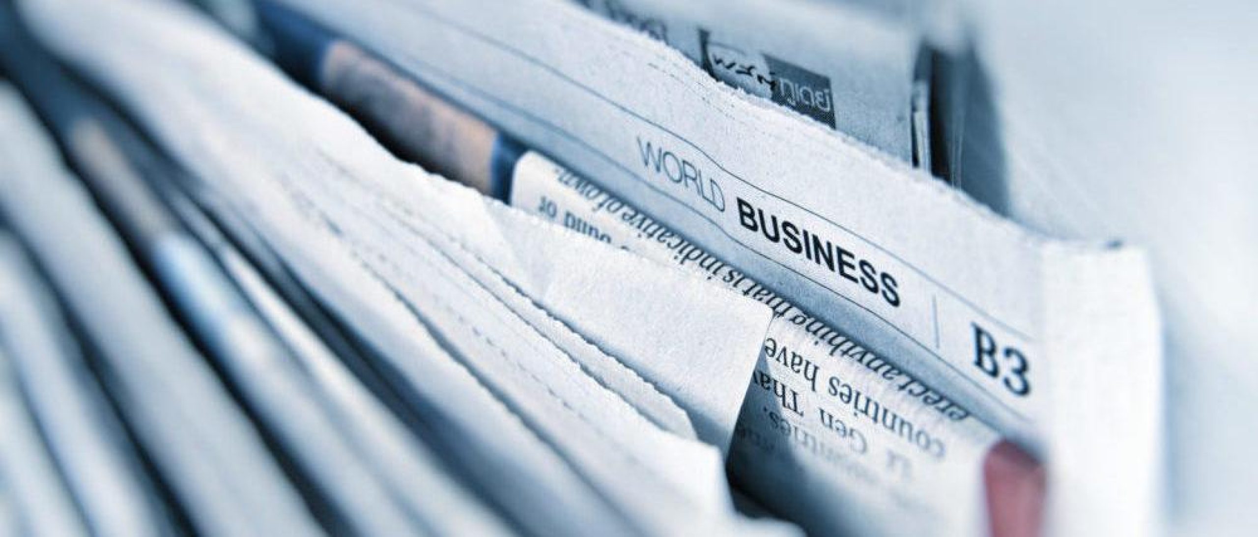 File cabinet stuffed with newspapers, showing the Business section