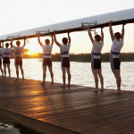 Athletics carrying a crew canoe over heads