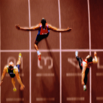 Athletes in race crossing finishing line, overhead view (Composite)